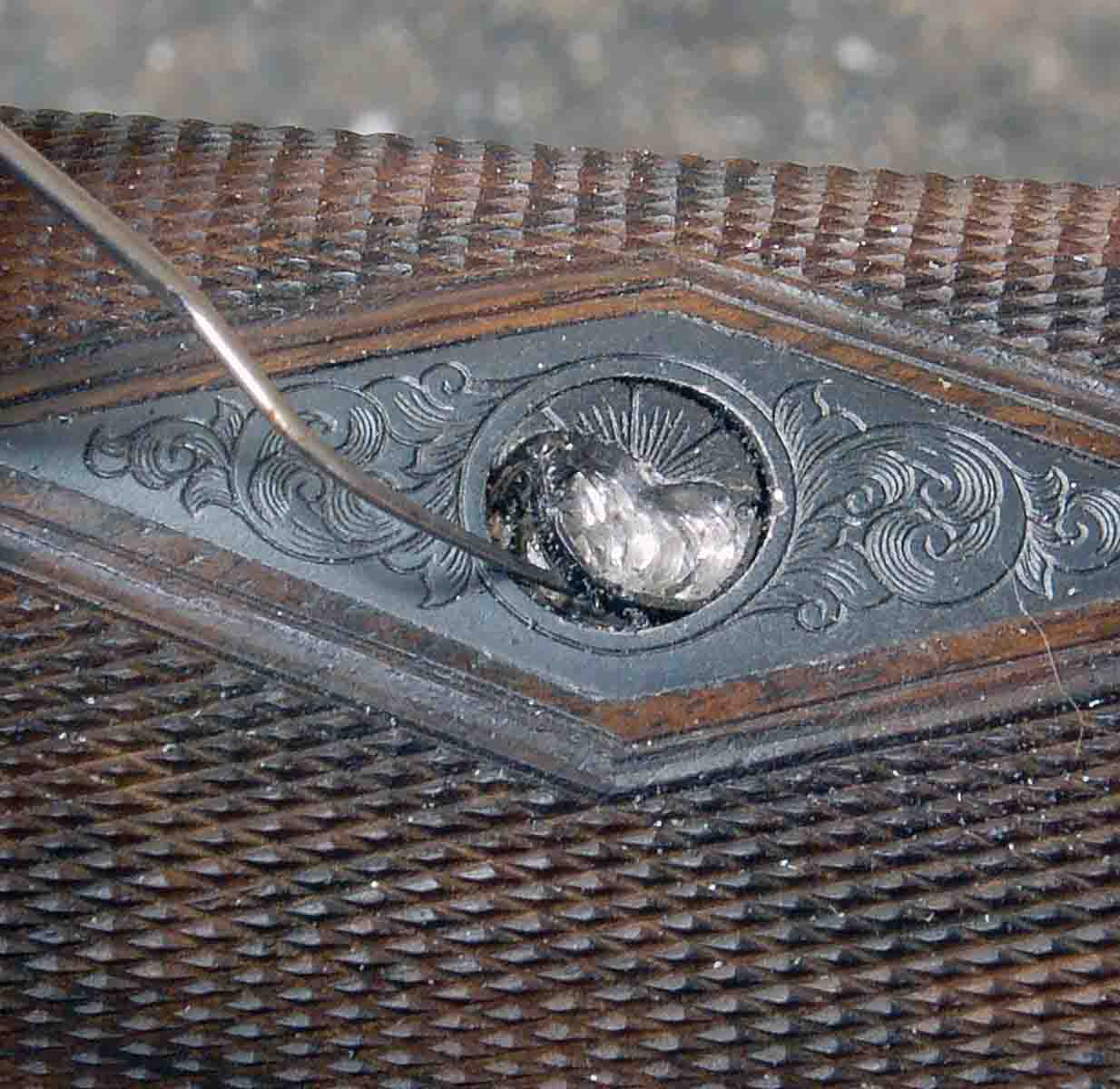 If epoxy bedding has gotten into screw threads, the only plan is to cut out the screw head using a carbide burr in a Dremel tool. Grind almost to the edge of the screw head, then pick out any tiny remaining pieces. Brown epoxy is visible around the edge of  this screw head.